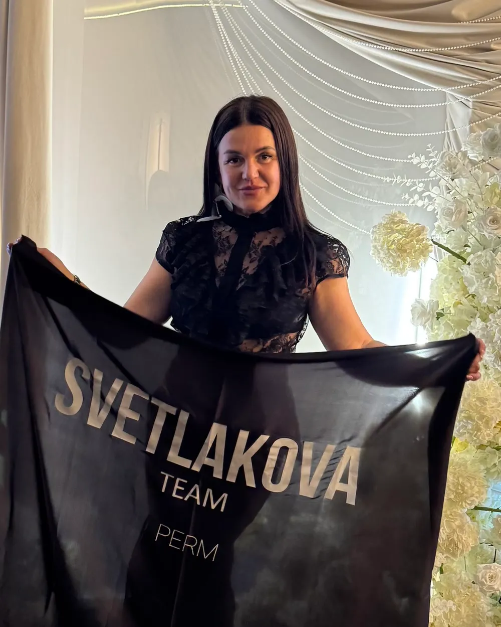 Ксения Субботина с флагом команды SVETLAKOVA TEAM рядом с кубками